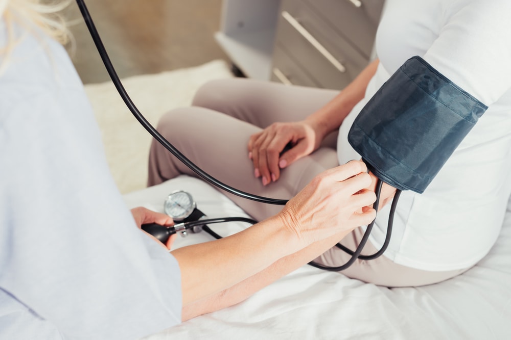 Nurse taking blood pressure of a patient in order to provide exceptional nursing care.