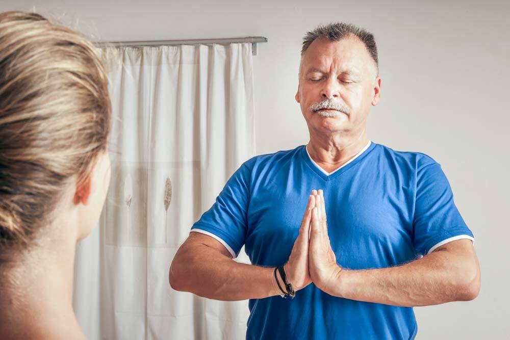 Senior man doing yoga to benefit a healthy lifestyle