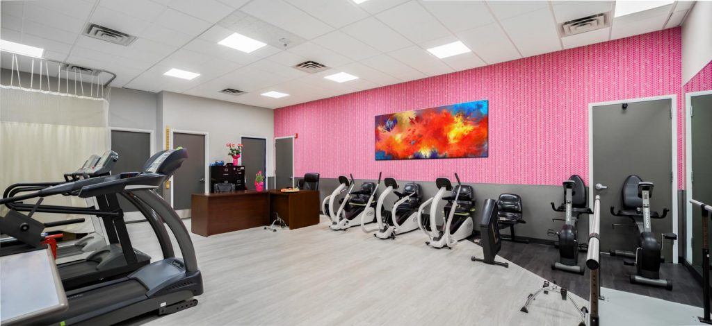 Gym area of Fairview ADC with multiple treadmills, cycles and other exercise equipment.