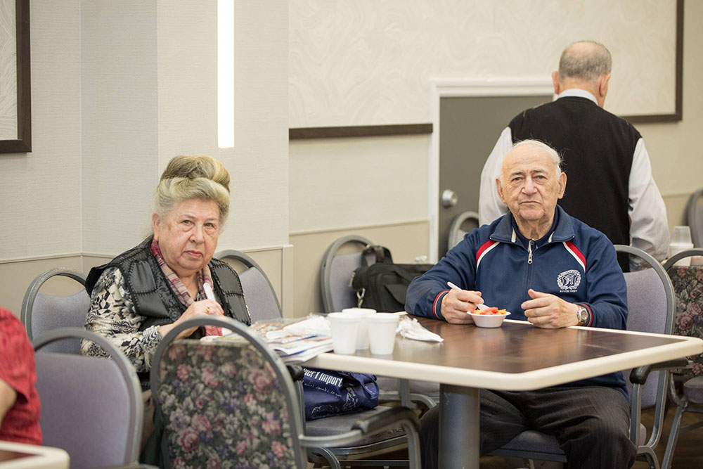 Two senior patients sitting on the dining table and eating at Fairview ADC. Best Place for Someone with Early Dementia.