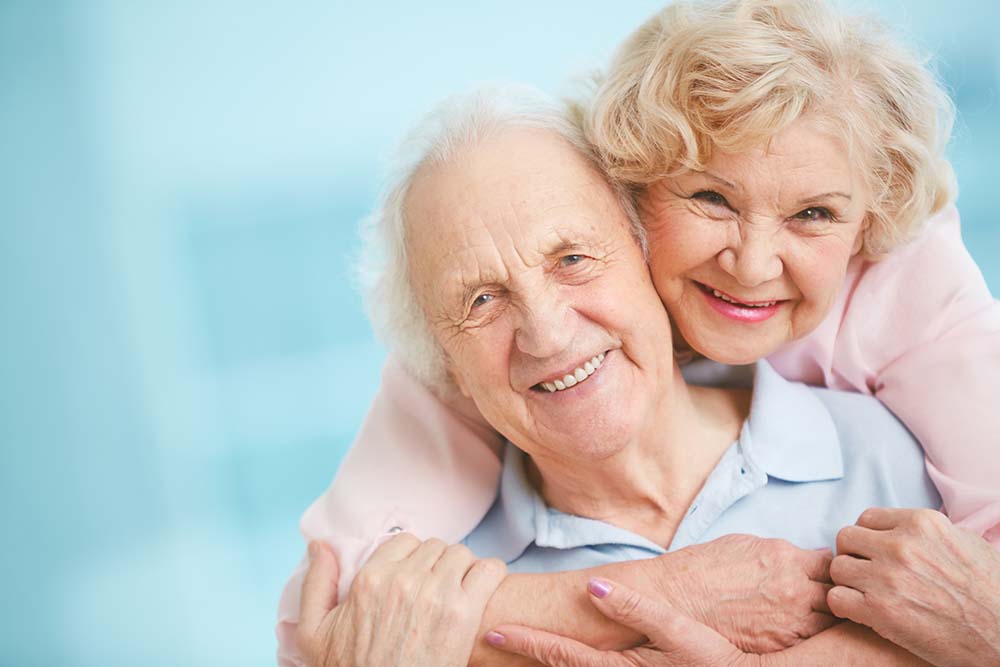 Happy senior woman taking care of his husband suffering from alzheimers disease.