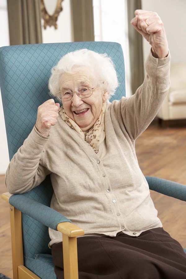 Senior woman performing chair aerobics, adult day care center brooklyn nyc