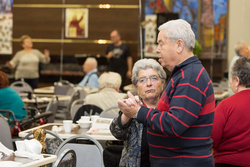 Senior couple dancing while holding hands. Fun activities for elderly people at Fairview ADC.