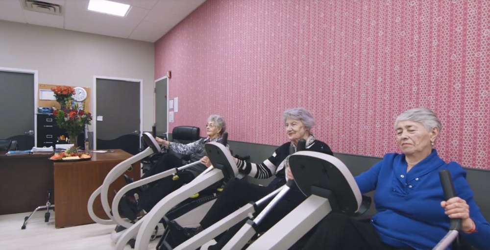 Three clients of Fairview ADC using cycling machines for physical therapy to reduce arthritis pain.
