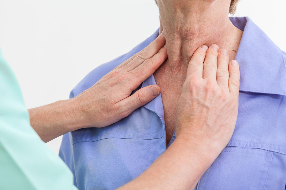 Doctor checking patient throat to diagnose thyroid disease