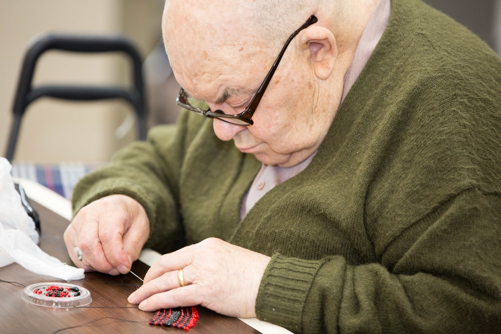 Senior man sewing to keep his brain healthy and to prevent cognitive decline