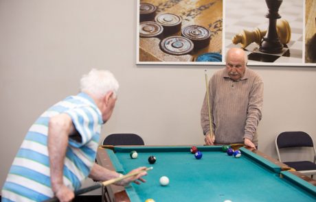 Elderly playing snooker for entertainment in russian-speaking elderly care