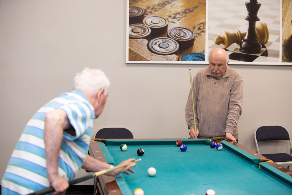 Elderly playing snooker for entertainment in russian-speaking elderly care