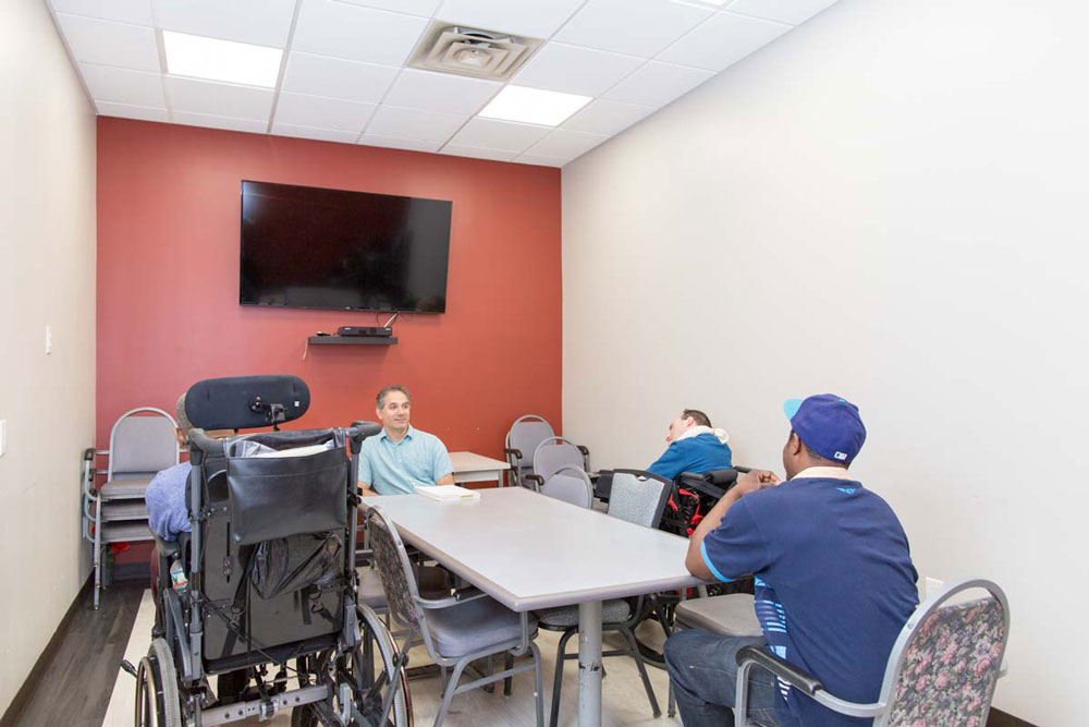 Elderly man discussing his mental health problems with doctor while keeping the social distance.