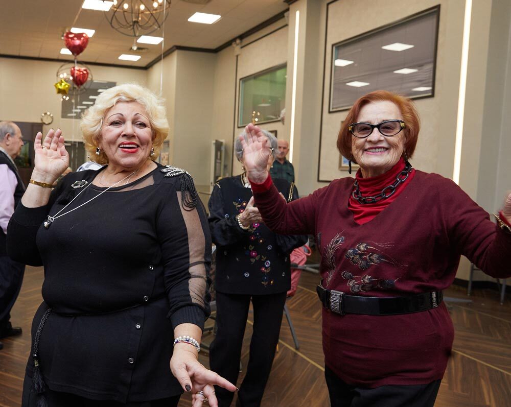 Two happy women dancing during dance therapy session. Dancing helps preventing functional decline in elderly.