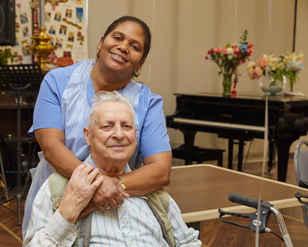 Black recreation nurse putting smile on an elderly man in order to boost emotional health