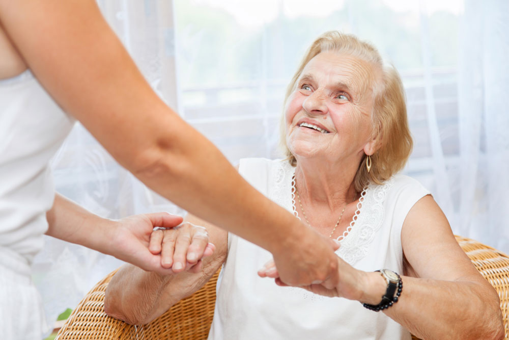 Nurse providing care for elderly woman with happy emotions