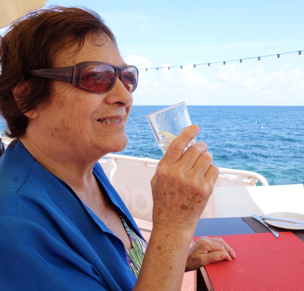 Elderly woman drinking water from glass to avoid heat exhaustion