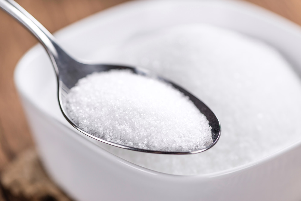 A portion of refined sugar on spoon