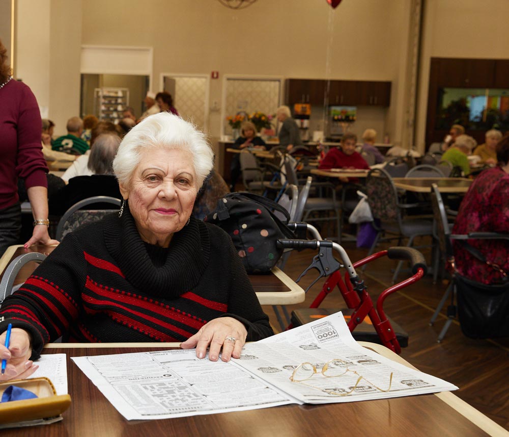 Elderly woman solving puzzles as a part of cognitive behavioral therapy