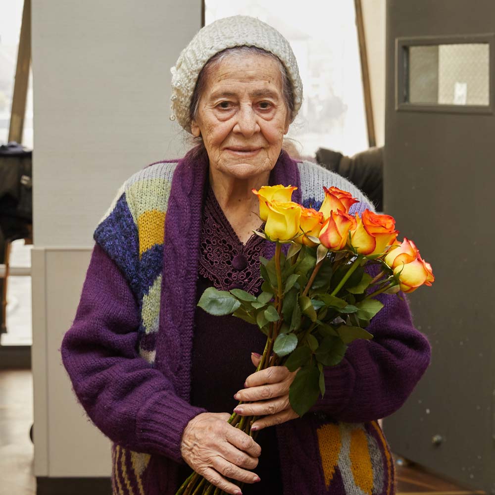 Elderly woman with depression holding bouquet 