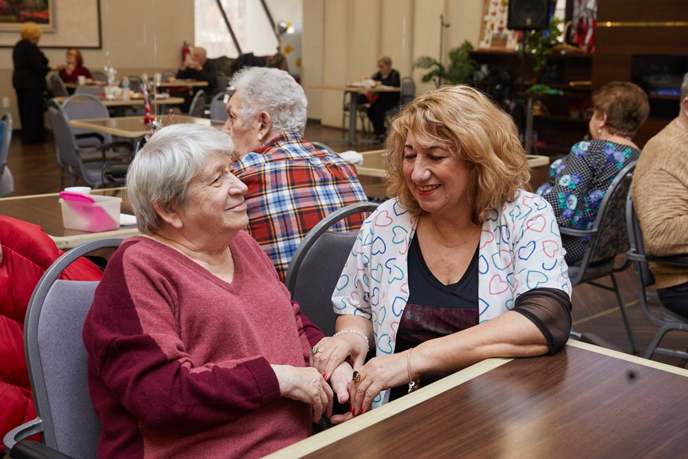 Elderly women talking to each other living with a brain injury