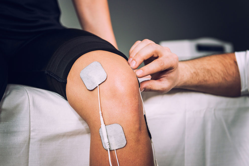 Electro stimulation on knees as a part of physical therapy used to overcome the causes of joint stiffness