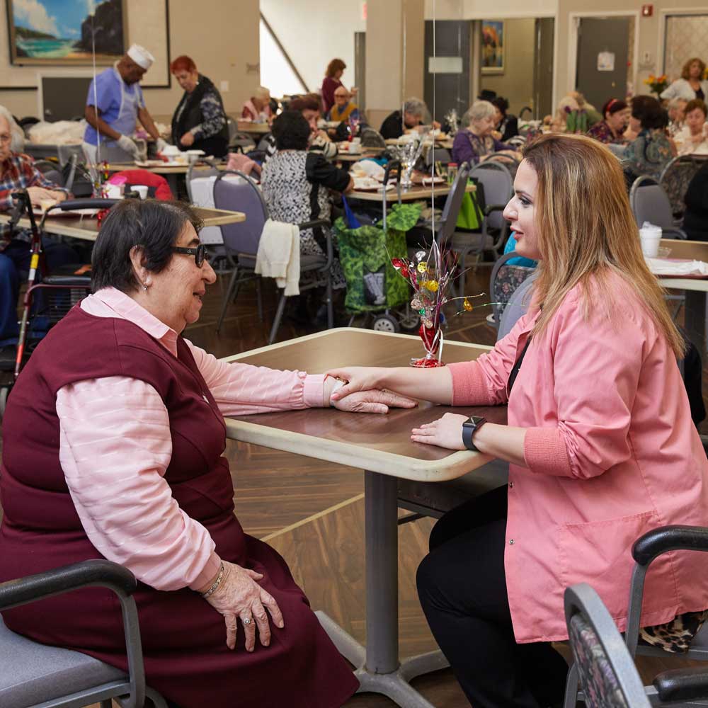 Therapist holding hands of a senior woman suffering from tinnitus or pulse in the ear.