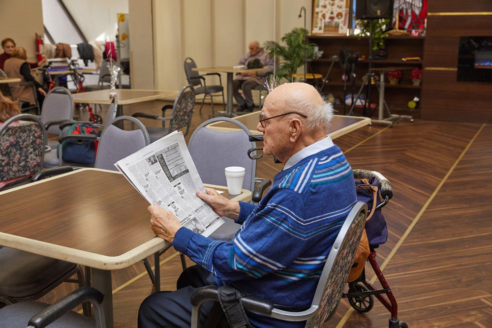 Senior man reading newspaper as relaxing activity to avoid distress.
