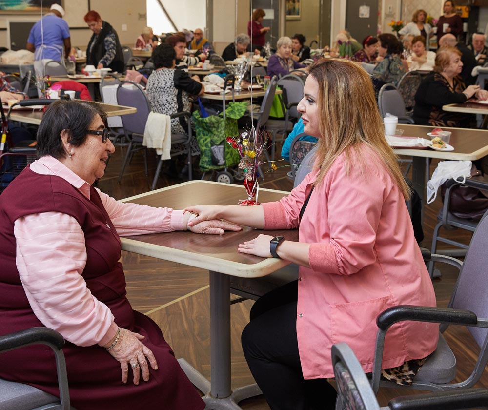 Nurse holding hands of an elderly woman having common health concerns