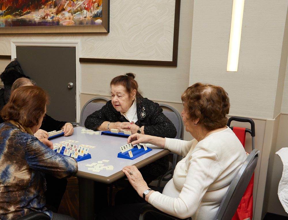 Senior women playing mind games during geriatric therapy session to stimulate the brain.
