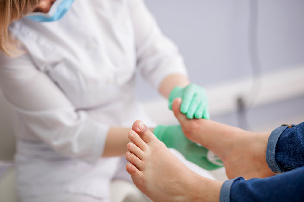 Podiatrist checking foot of a diabetic patient suffering from diabetic neuropathy complications.